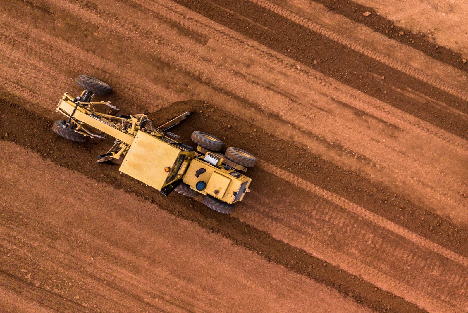 Motor grader finishing commercial laydown yard near Seminole Texas