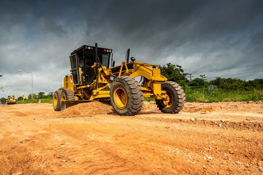 Motor grader finishing commercial laydown yard near Seminole Texas